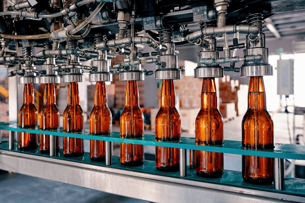 Beer bottles filling on the conveyor belt in the brewery factory