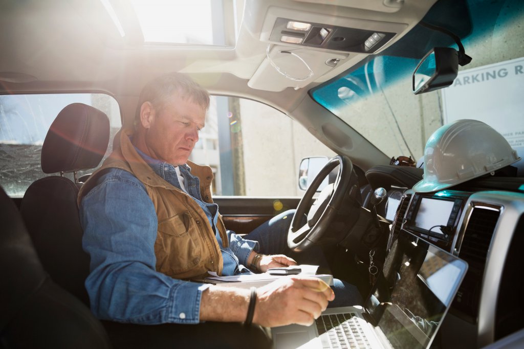 Foreman using laptop in truck