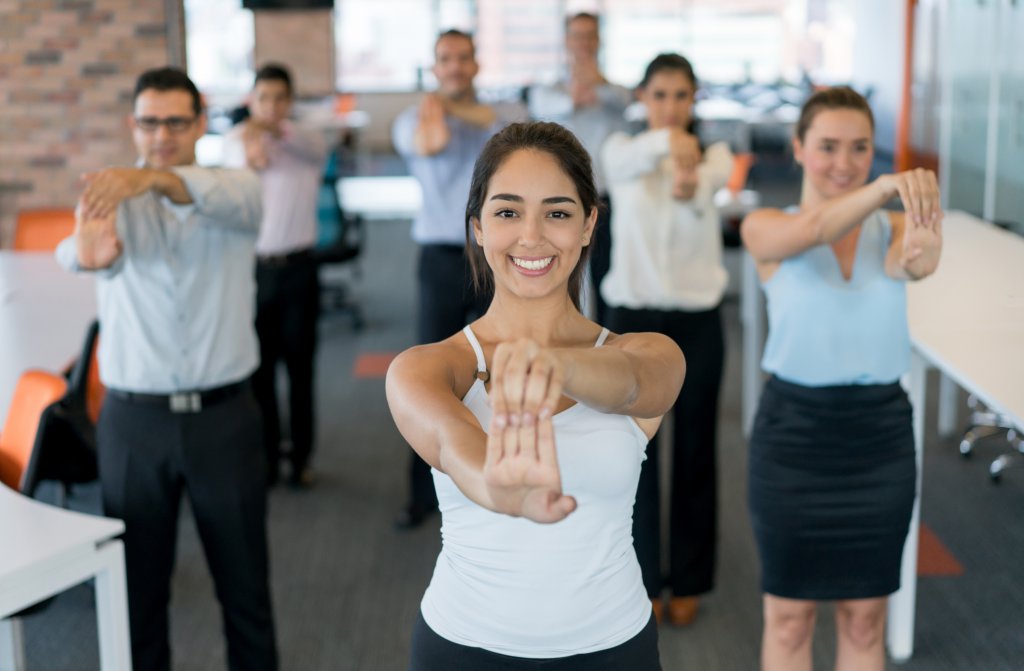 Business people on an active break at the office stretching and looking very happy - healthy lifestyle concepts