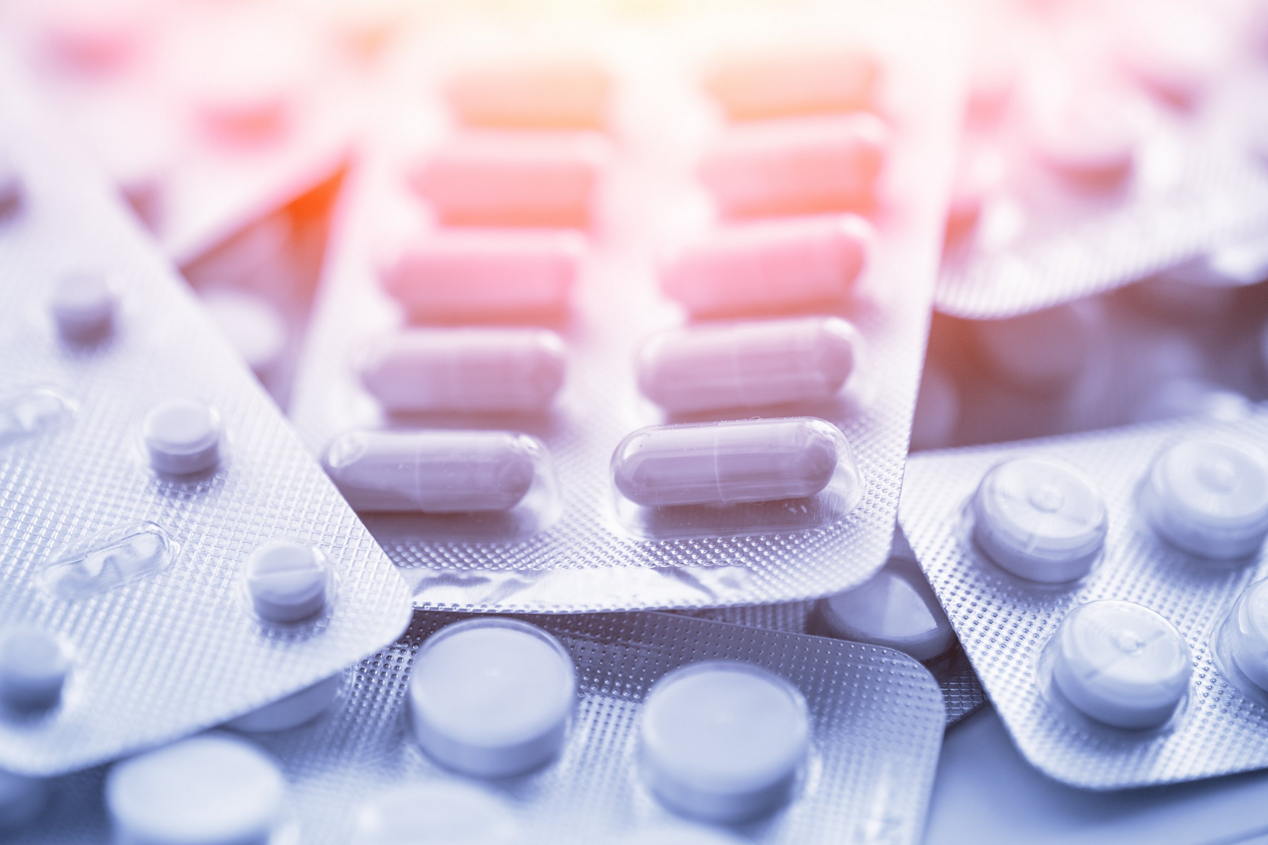 Different medicines: tablets, pills in blister pack, medications drugs, macro, selective focus, copy space, blue toned.