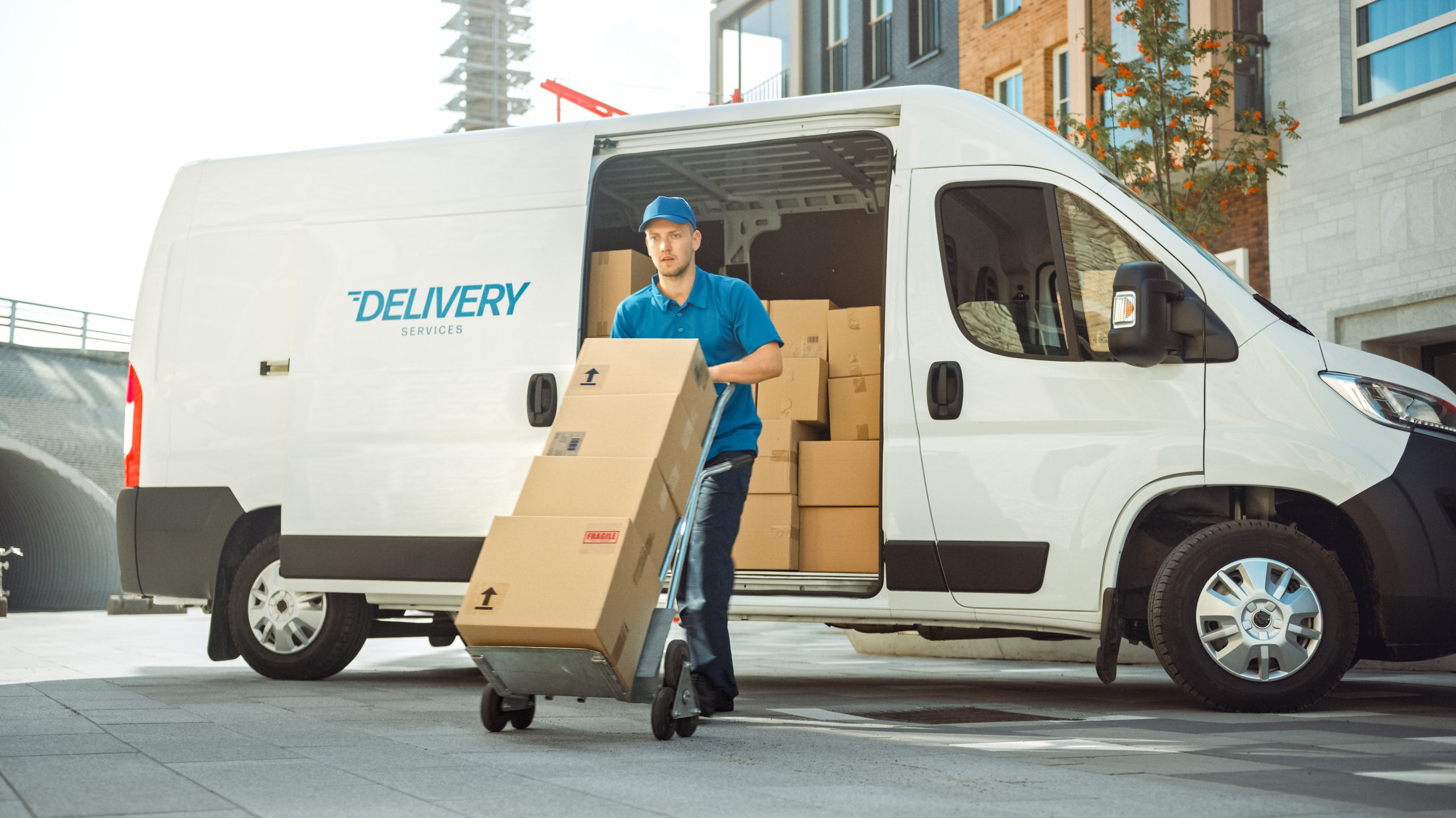 Delivery Man Pushes Hand Truck Trolley Full of Cardboard Boxes H