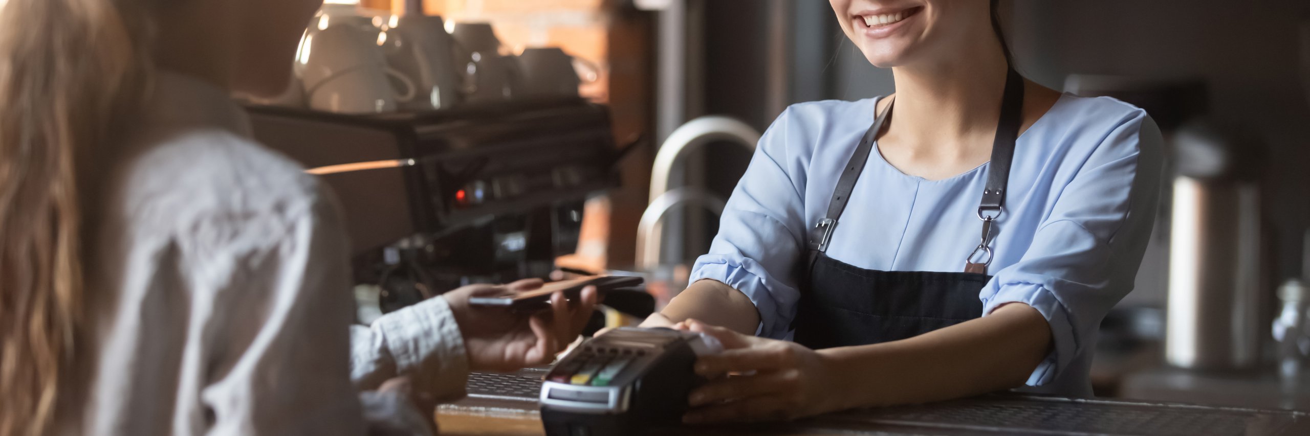 Customer in bar makes payment using smartphone application horizontal image