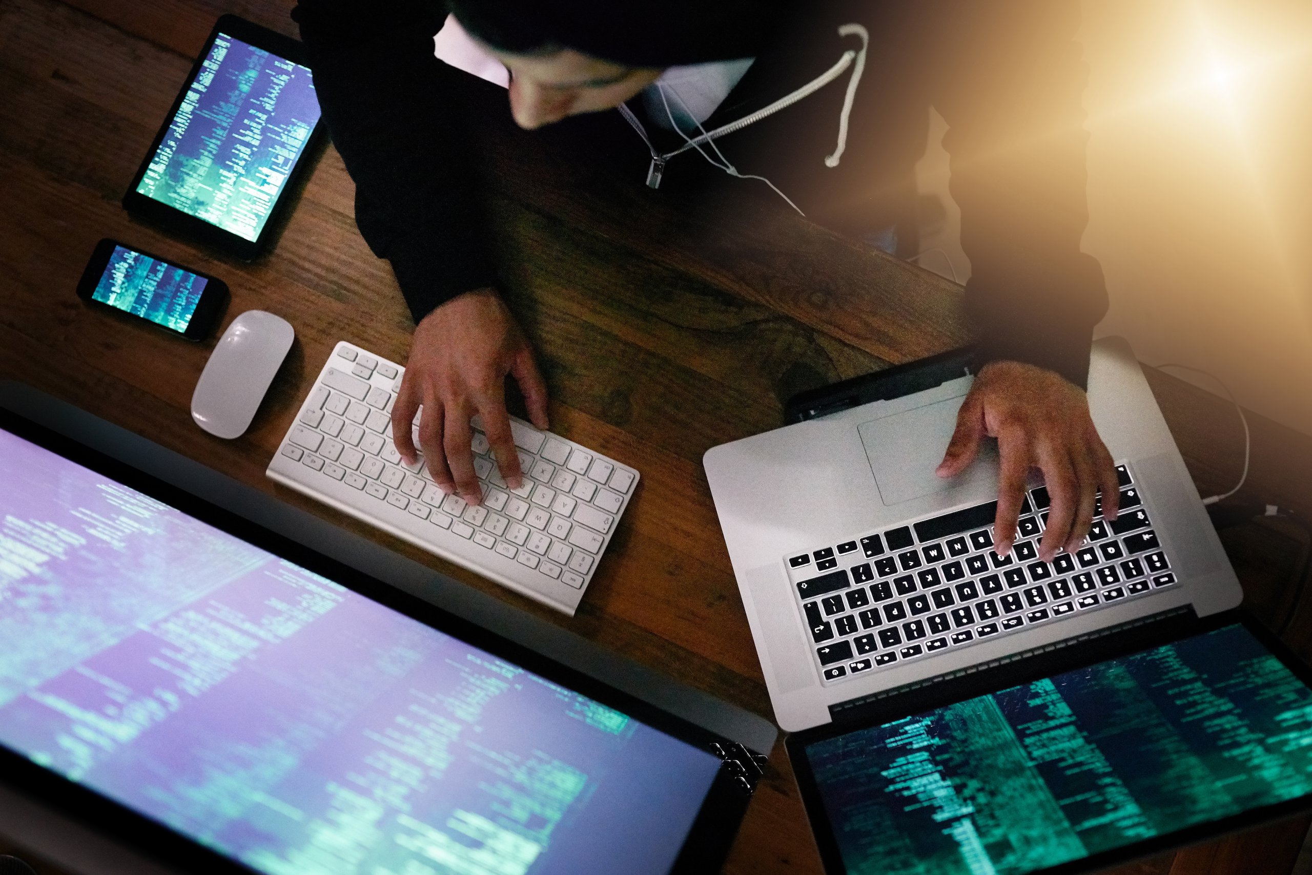 High angle shot of a hacker cracking a computer code in the dark.